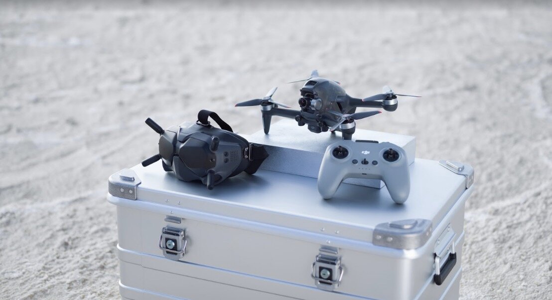 Dron DJI FPV Combo szary widok od góry na dron i kontroler leżące na skrzynce