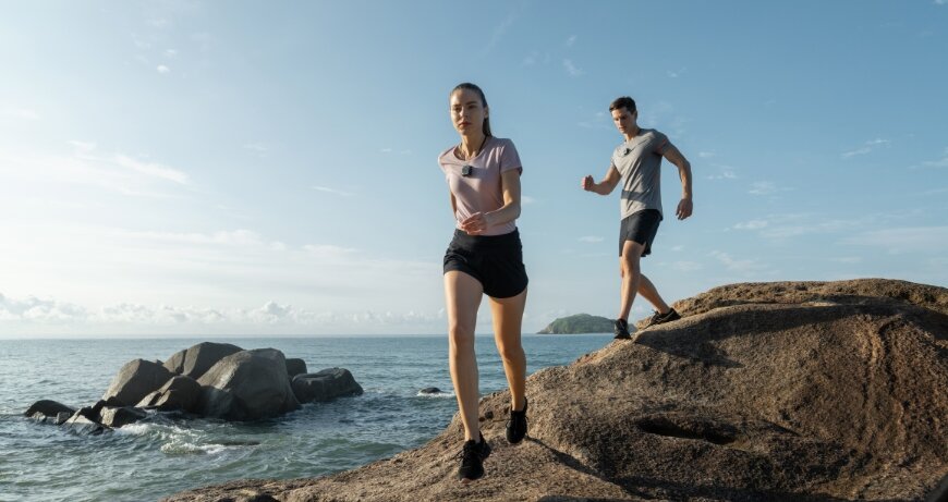 Kamera DJI Action 2 Dual-Screen Combo widok na biegnącą kobietę i mężczyznę z kamerą zawieszoną na szyi
