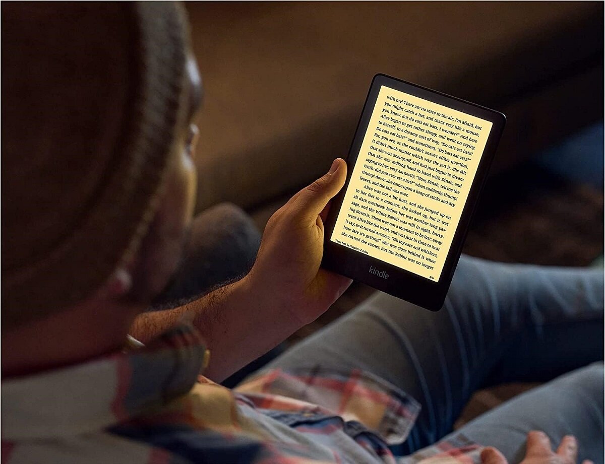Czytnik ebook Amazon Kindle Paperwhite 5 16 GB czarny widok na mężczyznę czytającego ebook na kanapie