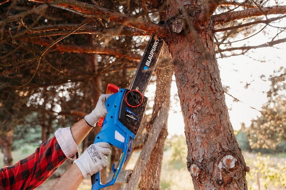 Piła łańcuchowa Blaupunkt CS3010 grafika przedstawiająca mężczyznę ścinającego gałąź drzewa