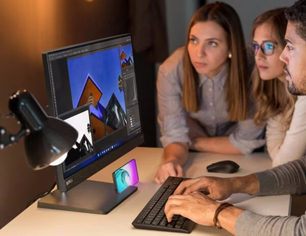 Komputer AiO Lenovo ThinkCentre neo 50a 24 grafika przedstawia ludzi przed włączonym monitorem obok lampka podświetlająca klawiaturę i mysz