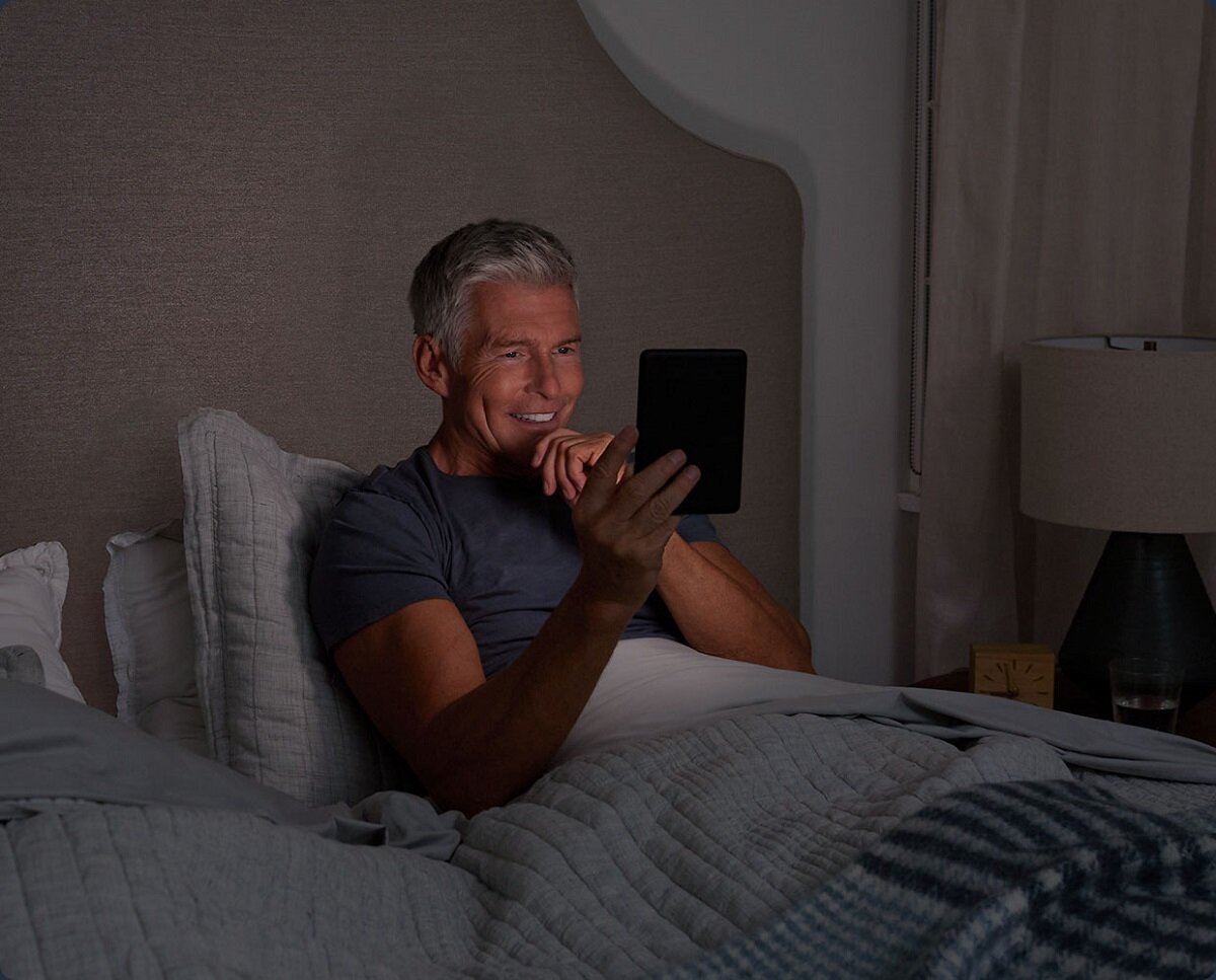 Czytnik ebook Amazon Kindle 11 16 GB czarny widok na mężczyznę czytającego w łóżku