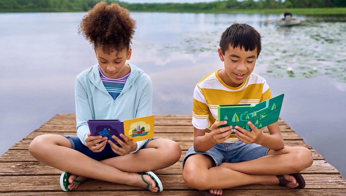 Czytnik ebook Amazon Kindle Paperwhite Kids 8 GB czarny dwoje dzieci czytających na pomoście nad jeziorem
