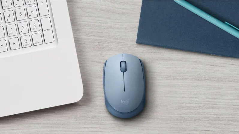 Mysz Logitech M171 od frontu, na blacie biurka z laptopem oraz zeszytem w tle